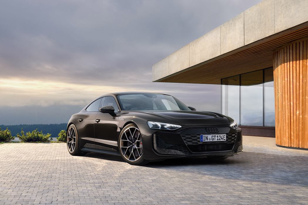 郊外の家の前に停まる黒いアウディ RS e-tron GT パフォーマンス エクスクルーシブエディション