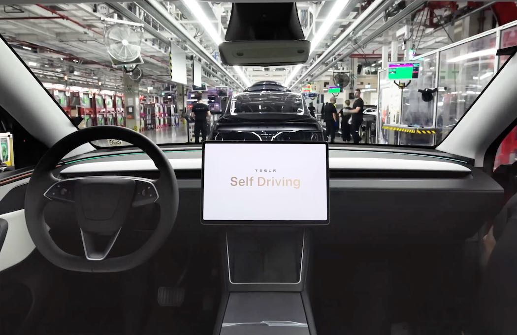 工場でのテスラ車モニターにはFSDの文字